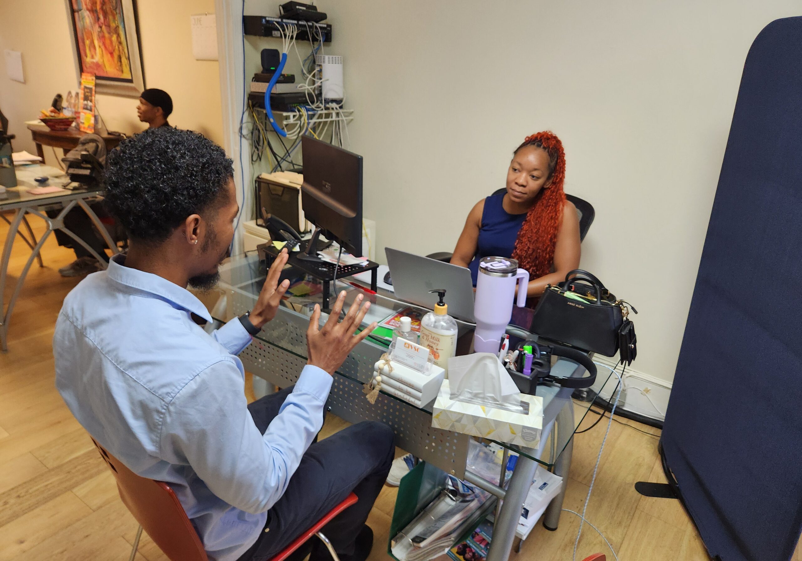 VSC client talks with case worker at office desk
