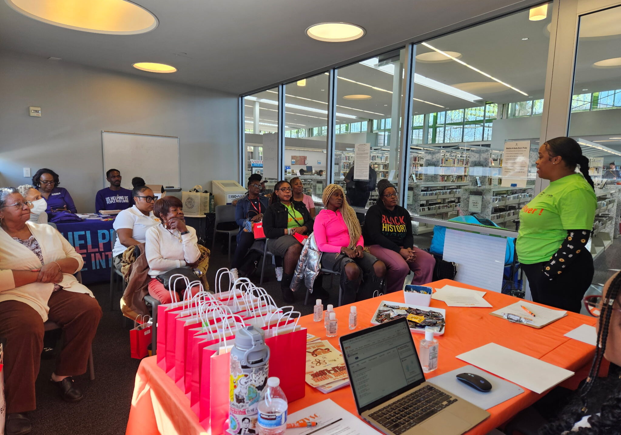 H.E.R support group clients sitting in office listening to a presentation
